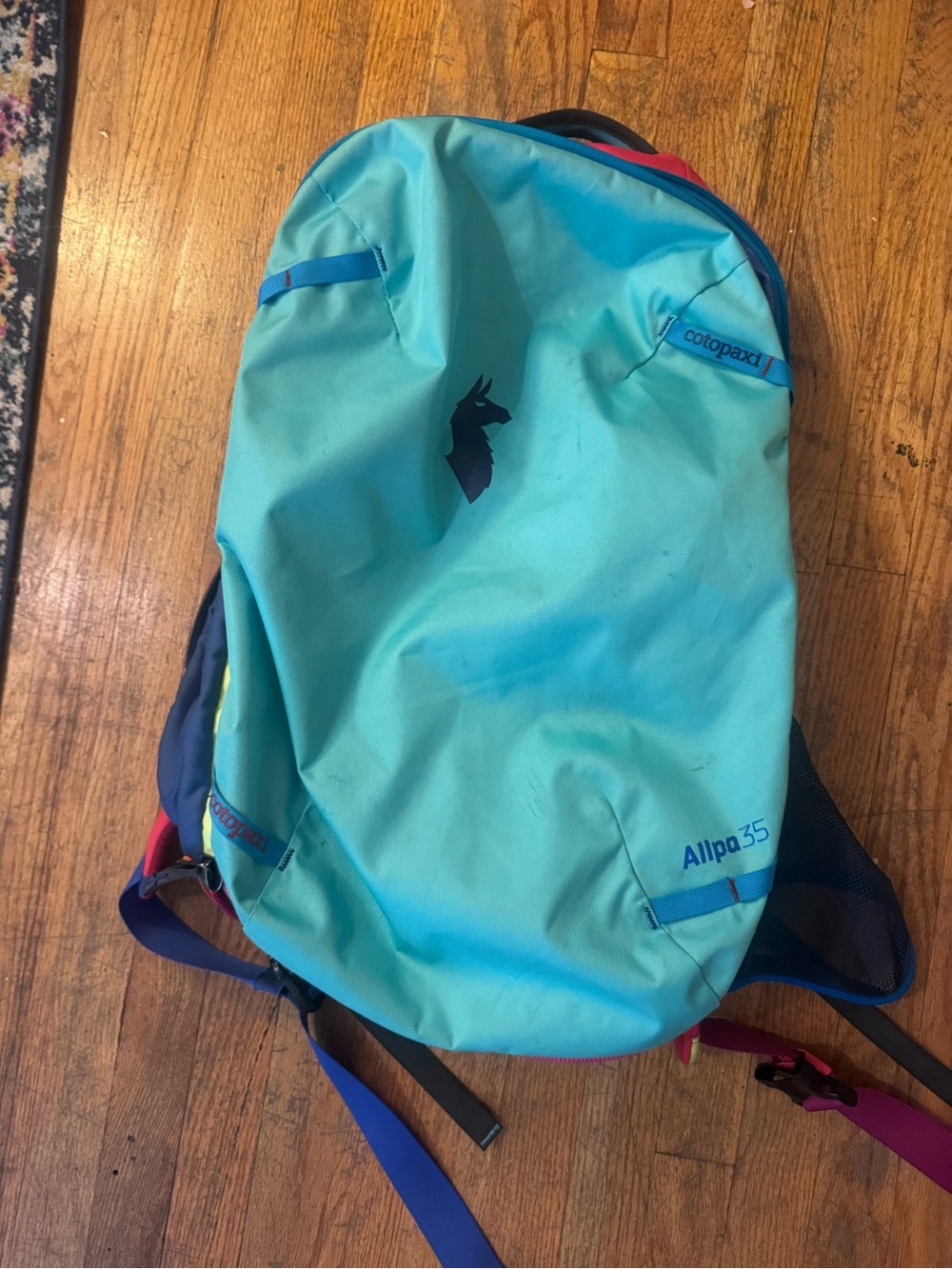 cotopaxi turquoise backpack with navy and magenta accents